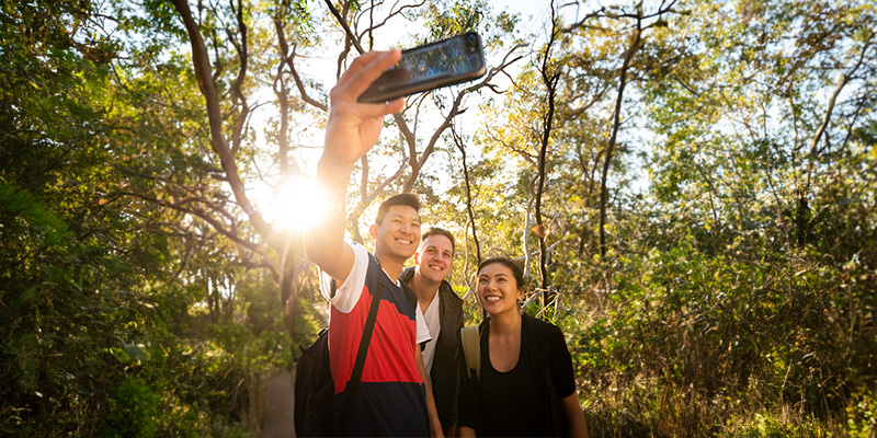 Three students taking a selfie in nature